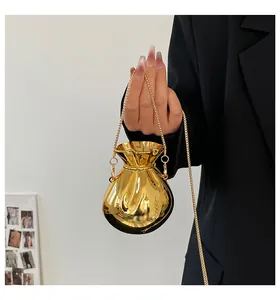 Dettaglio di una mini borsa da sera dorata con finitura a specchio e catena metallica