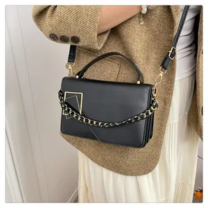 Détail du sac à main en cuir PU noir avec boucle dorée et bandoulière en chaîne