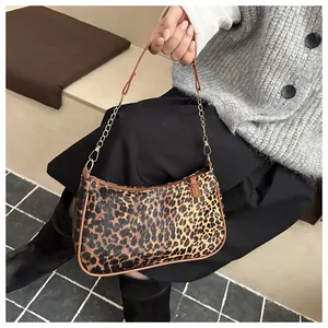 Detailed close-up of retro leopard print crescent bag with leather strap and gold chain