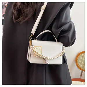 Détail du sac à bandoulière blanc avec chaîne dorée et fermoir à boucle carrée élégant