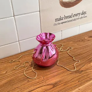Borsa a secchiello rosa metallizzato con coulisse e catena dorata vista dall'alto