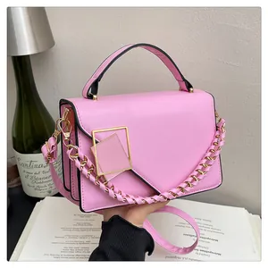 Détail du sac à bandoulière rose avec boucle dorée et intérieur à trois compartiments