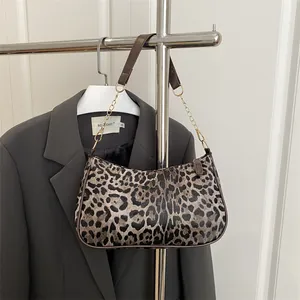 Retro leopard print crescent underarm bag with gold chain strap on a blazer background