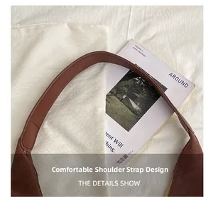 Detail of wide comfortable shoulder strap and fine stitching on dark brown leather tote