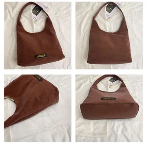 Detail of brown leather tote bag showing JACQEUE label on textured matte surface