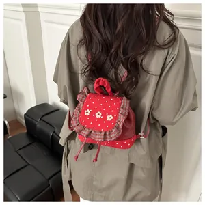 Détail du mini sac à dos rouge à pois avec dentelle à carreaux et broderie fleurie