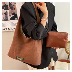 Detail of a large brown suede tote bag and matching pouch showing premium texture and capacity