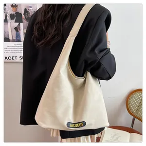 Side view of beige hobo bag with wide shoulder strap showing drape and capacity