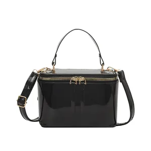 Minimalist black patent leather box bag with gold hardware and top handle for women
