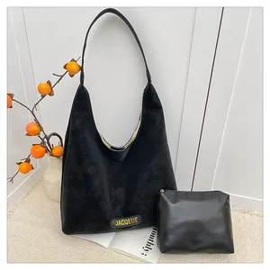 Detail of black tote set with JACQEUE branding and matching small zipper pouch