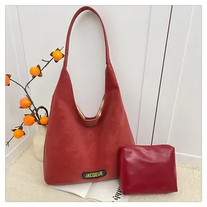 Detailed view of red matte faux leather tote bag and matching inner pouch with brand tag