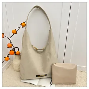 Detailed close-up of cream white leather tote bag with gold brand logo and matching pouch