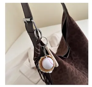 Détail d'un porte-clés baseball avec gant et batte sur un sac à main motif léopard