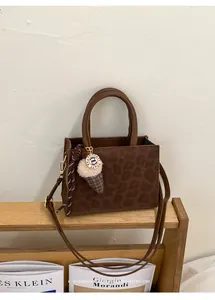 Detailaufnahme der Leoparden-Handtasche mit Seidenschal und Eiscreme-Anhänger