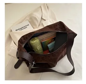Intérieur spacieux d'un sac à bandoulière léopard avec parapluie et livres rangés