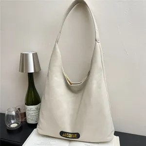 Elegant off-white large capacity tote bag with Jacqueue logo on a minimalist book background