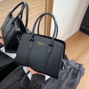 Black faux crocodile pattern tote bag with double handles and gold lettering detail