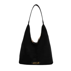 Minimalist black suede tote bag with golden logo lettering and spacious hobo design