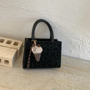 Schwarze Umhängetasche mit Leopardenmuster und luxuriösem Eiscreme-Anhänger im Detail