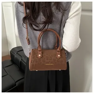 Detail of leopard print boston bag featuring gold lettering and smooth leather texture