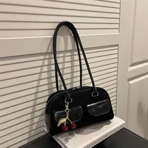 Chic black faux suede shoulder bag with dual front pockets and a cherry charm