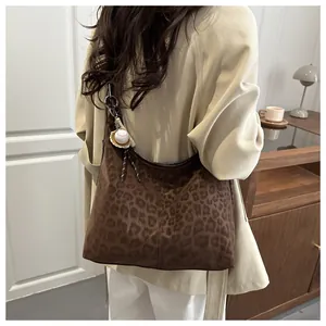 Détail du sac hobo à imprimé léopard avec pendentif mini batte de baseball chic
