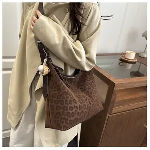 Détail d'un sac à bandoulière léopard avec pendentif baseball et grande capacité