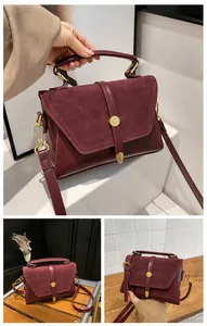 Detail of burgundy PU leather and suede handbag with gold buckle and adjustable strap