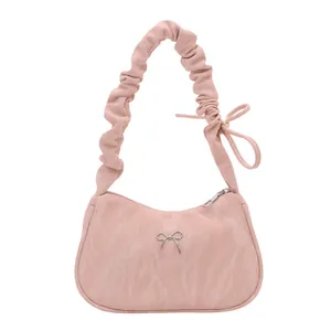 Pink crescent underarm bag with pleated texture and silver bow detail on white background