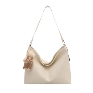 Borsa hobo beige oversize minimalista con trama litchi e ciondolo a forma di orso