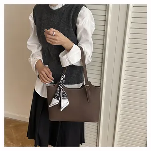 Close-up of dark brown lychee leather tote bag featuring a cute bear pattern silk scarf