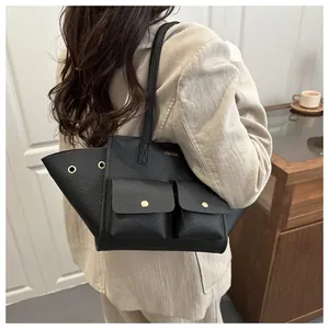 Détail du sac cabas noir en cuir grainé avec design en forme d'ailes et boucles dorées