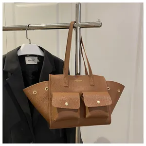 Détail du sac cabas marron texture litchi avec boucles dorées et poches à rabat
