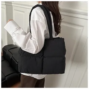 Grande borsa shopper nera trapuntata indossata da una modella con camicia bianca