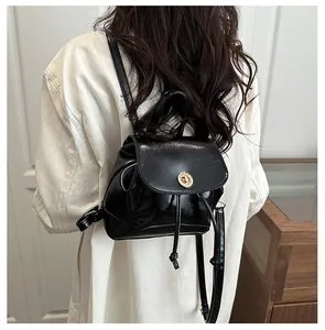 Détail du dos d'un mini sac à dos noir en similicuir avec fermoir rotatif doré