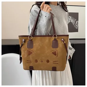 Détail du cabas en daim marron avec broderie chat et rivets métalliques élégants