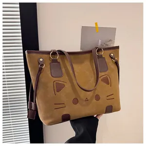 Détails d'un grand sac cabas jaune avec broderie chat et anneaux en métal doré