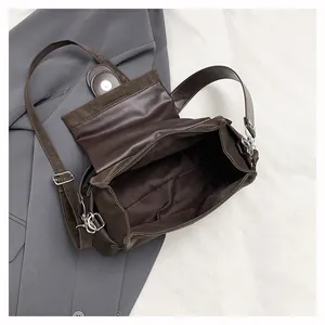 Detail of dark brown vintage messenger bag with magnetic flap and spacious interior