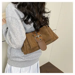 Detail of brown suede baguette bag with vintage silver buckle and pleated texture