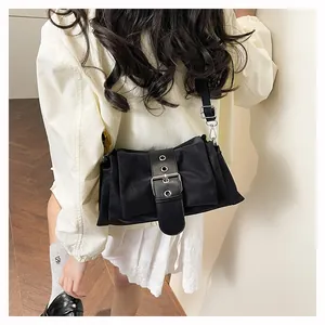 Close-up of black baguette bag with silver metal buckle and adjustable shoulder strap