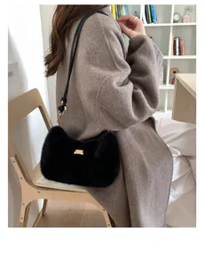 Sac bandoulière chic en fausse fourrure noire avec boucle dorée sur tenue d'automne