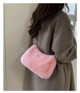 Détail d'un sac à bandoulière en peluche rose doux avec des ferrures dorées élégantes