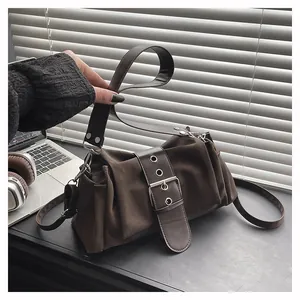 Close-up of textured dark brown baguette bag featuring a wide strap and silver buckle