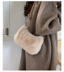 Vue détaillée du sac bandoulière en fausse fourrure beige avec plaque dorée et bandoulière