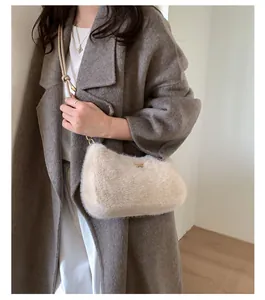 Détail du sac bandoulière en peluche beige avec bandoulière nouée et anneaux dorés