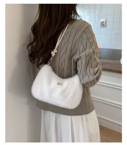 Détail du sac bandoulière en peluche blanche avec bandoulière tressée et fermoir doré