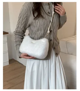 Détail d'un sac à bandoulière en peluche blanche, texture douce et design oreilles de chat