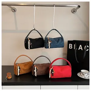 Close-up of suede-textured cylinder bags in five colors with beaded charms and accessories