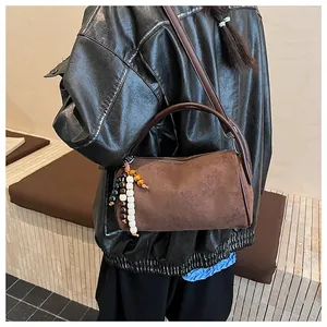 Detail of vintage matte brown cylinder bag featuring decorative colorful wooden beads