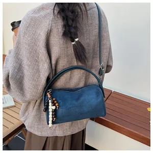 Retro blue frosted pillow bag with wood bead charm shown in an autumn lifestyle setting